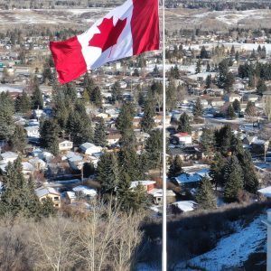 Canadian flag flying over snowy landscape.