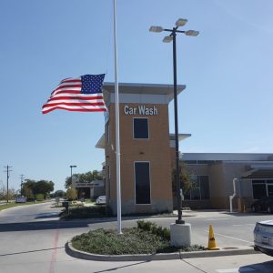 American flag flying outside a car wash building on a sunny day.