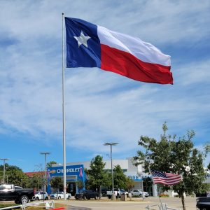 Texas flag flying at a car dealership.