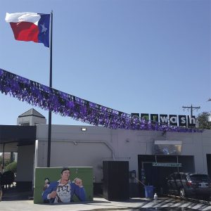 Outdoor scene with a Texas flag and colorful decorations.