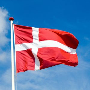 The Danish flag waving against a clear blue sky.