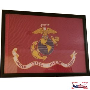 Framed United States Marine Corps emblem on a red background.