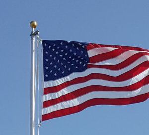 American flag waving against a clear blue sky.