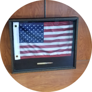 Framed American flag displayed on a wooden surface.