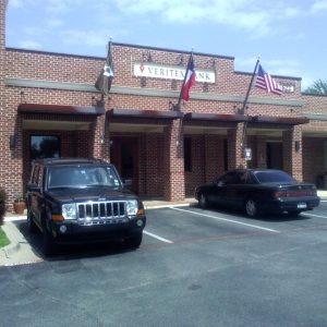 Front view of a brick police station with two parked vehicles.