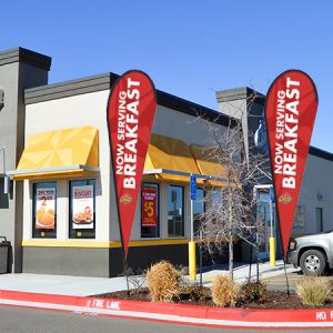 Fast-food restaurant with breakfast flags outside.