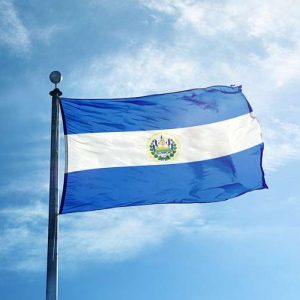The national flag of El Salvador waving against a blue sky.