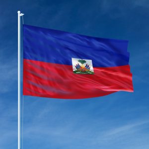 The national flag of Haiti waving against a clear blue sky.