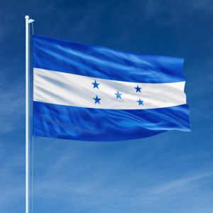 The flag of Honduras waving against a clear blue sky.